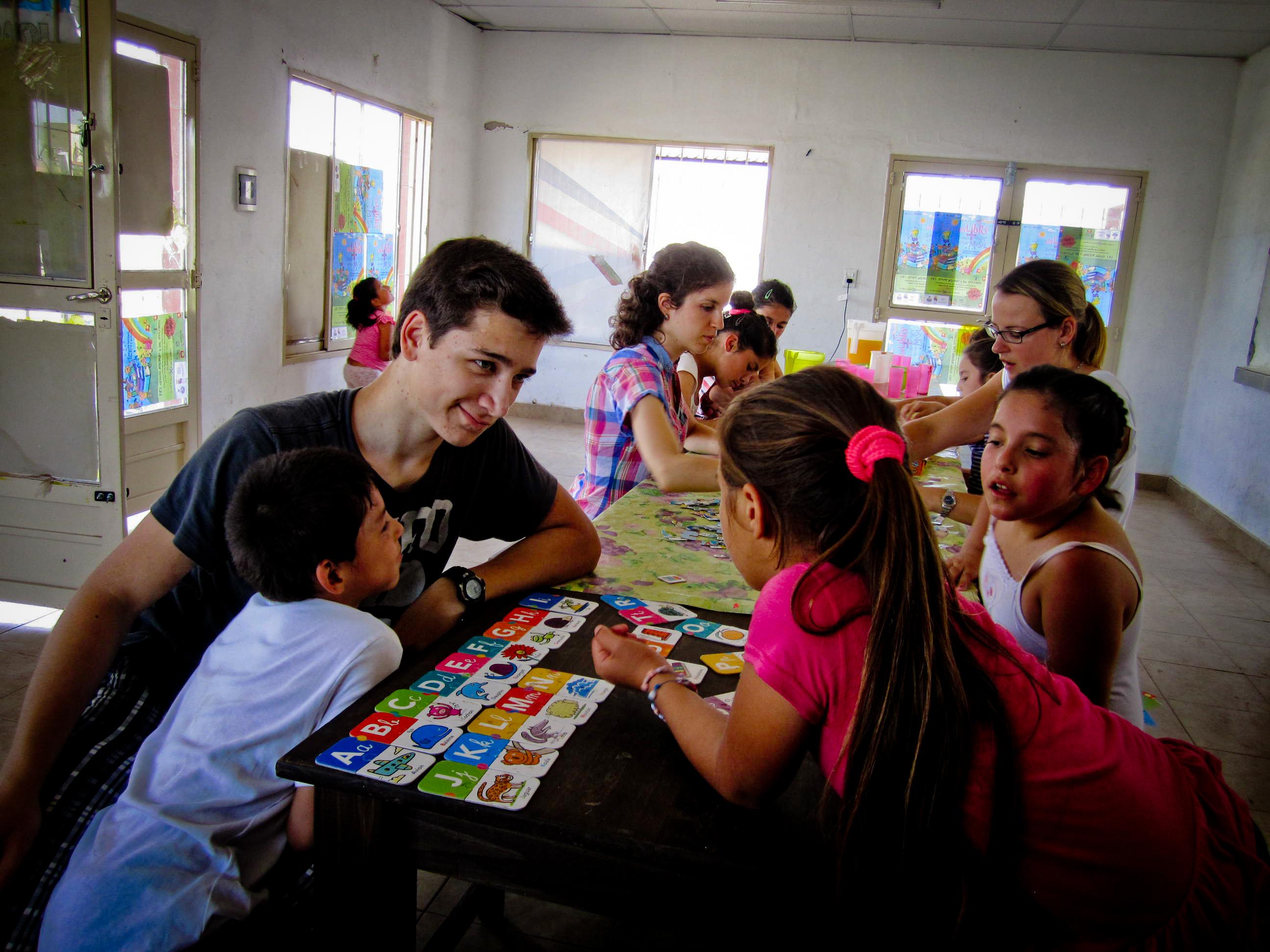 Projects Abroad volunteer teaching in Argentina helping a young girl as she learns the alphabet A teacher uses flashcards to help his student learn the alphabet during his teaching work experience in Argentina